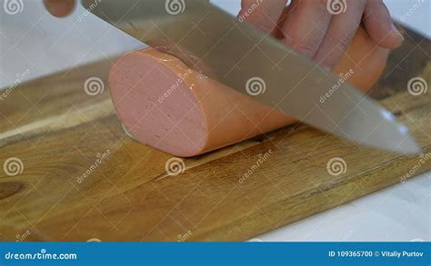 Chef Cutting Salami With A Knife On A Wood Board Close Up Stock Photo