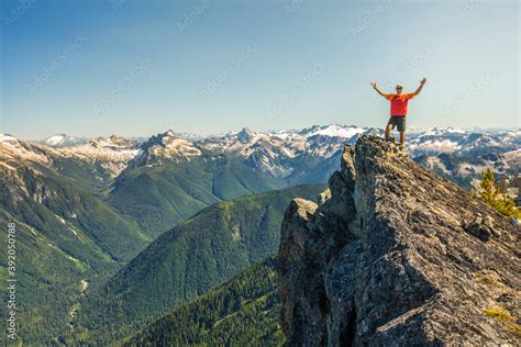 Hiker Raises Hands In Celebration After Reaching A Mountain Summit