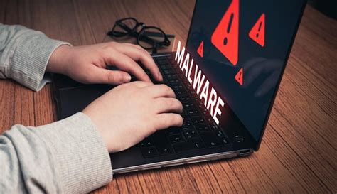 Mujer que usa una computadora portátil con alerta de malware virtual