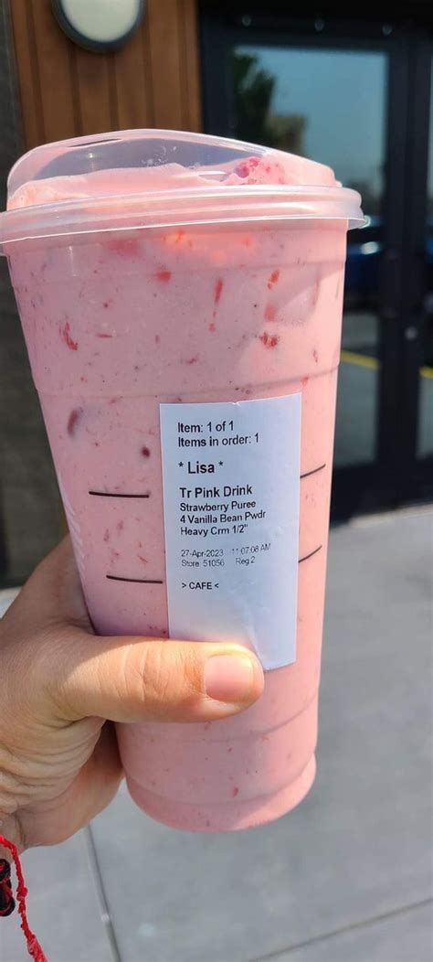 A Person Holding Up A Pink Drink With A Label On It S Cup Sleeve