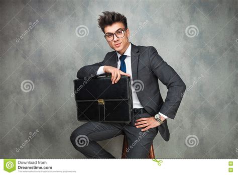 Businessman Leaning His Elbow Against Wall And Looks Away Stock Photo