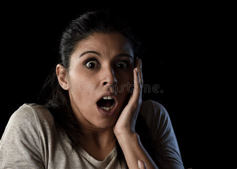 Young Beautiful Scared Spanish Woman In Shock And Surprise Face Expression Isolated On Black