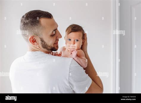 Young Caucasian Bearded Father Carrying Newborn Baby On Shoulder Male