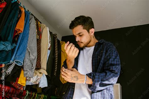 Hombre gay con camisa azul vistiéndose en su habitación Stock Photo Adobe Stock
