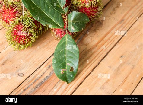 Nephelium lappaceum rambután rojo sobre broun junta Fruto de árbol