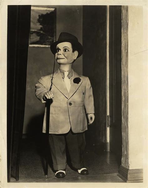 A Black And White Photo Of A Man In A Suit With A Puppet On His Head