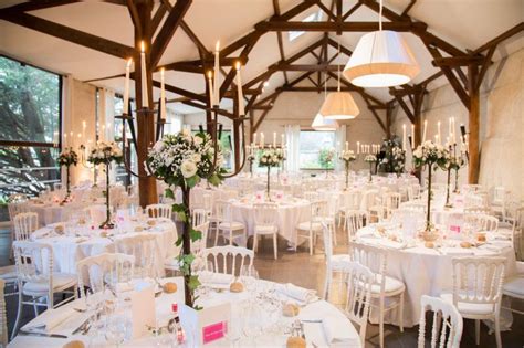 A Room Filled With Tables And Chairs Covered In White Linens