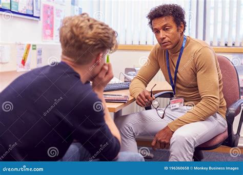 Male College Student Meeting With Campus Counselor Discussing Mental