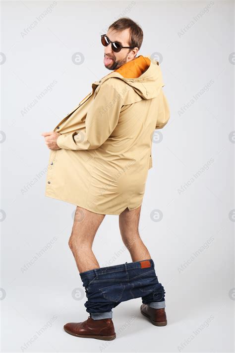 Exhibitionist Exposing Naked Body Under Coat On Light Background Stock