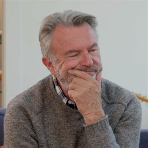 An Older Man Sitting On A Couch With His Hand Under His Chin