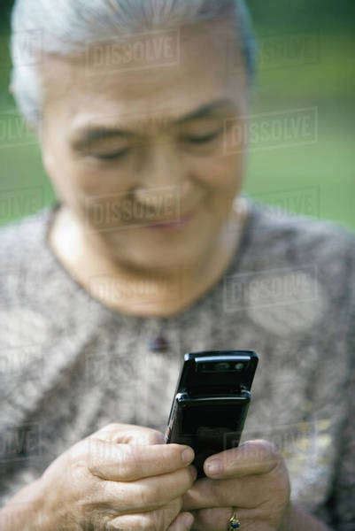 Senior Woman Dialing Cell Phone Stock Photo Dissolve