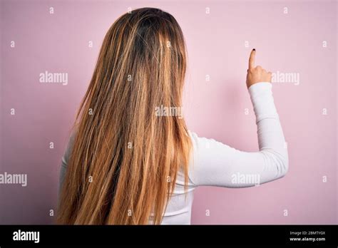 Jeune Belle Femme Blonde Avec Les Yeux Bleus Portant Un T Shirt Blanc Sur Fond Rose Posant En