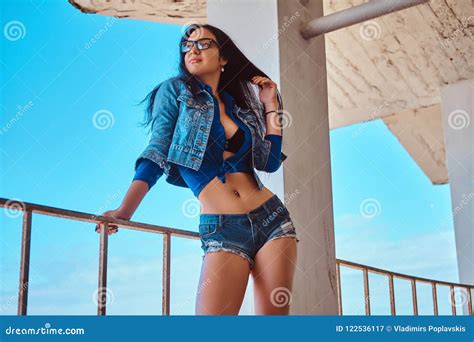 Seductive Brunette Girl Wearing Short Shorts And Jeans Jacket Posing