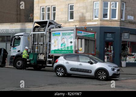 A Green Bin Which Has Just Emptied Its Contents Into A Bin Lorry Owned