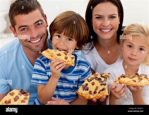 Retrato de familia comer pizza en el salón Fotografía de stock Alamy