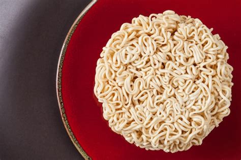 Premium Photo Close Up Raw Instant Noodles Isolated On A Red Plate