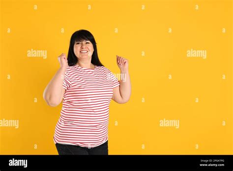 Happy Overweight Mature Woman On Orange Background Space For Text Stock Photo Alamy