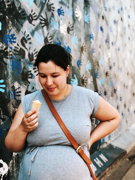 Premium Photo Pregnant Woman Having Ice Cream Cone Against Wall