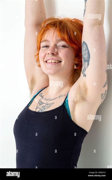 A Beautiful Woman In Her Mid Twenties With Tattoos And Unshaved Armpits With Her Arms Raised