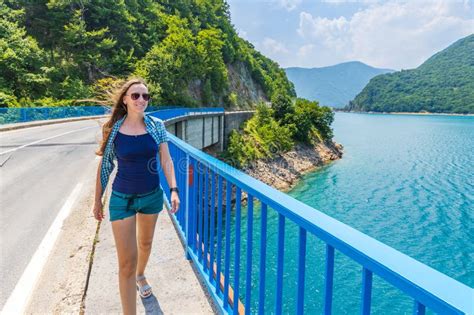 Young Woman Walking On The Bridge Across Piva Lake In Montenegro Stock