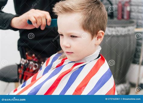 The Boy Kid Is Getting A Haircut In A Barbershop Hair Stylist Indoor