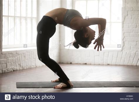 Young Attractive Woman In Ardha Chakrasana Pose White Loft Stud Stock