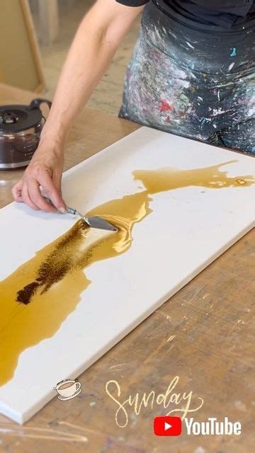 A Person Using A Knife To Paint On A Piece Of White Paper With Brown Ink