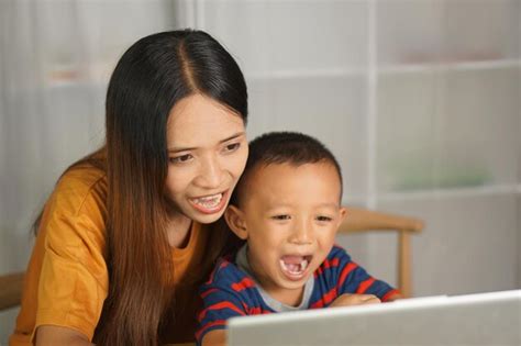 Premium Photo Mother And Son Watching Movies On Computer At Home Table