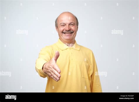 You Are Welcome Concept Cheerful Mature Man In Yellow T Shirt Shirt Gesturing Welcome Sign And