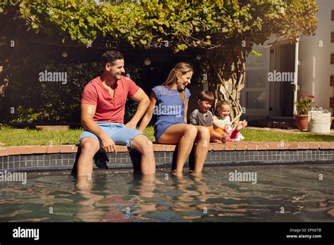 Couple Assis Sur Le Bord De La Piscine Avec Leurs Enfants Profiter D