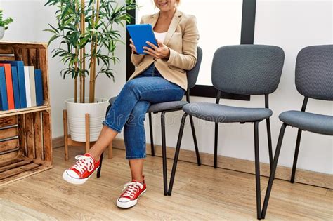 Middle Age Blonde Woman Smiling Confident Using Touchpad At Waiting