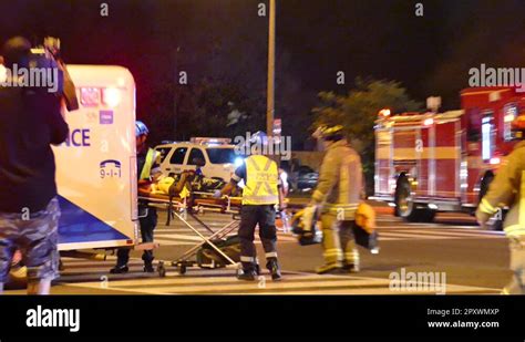 Paramedics And Firefighters Transporting Patient In A Ambulance After