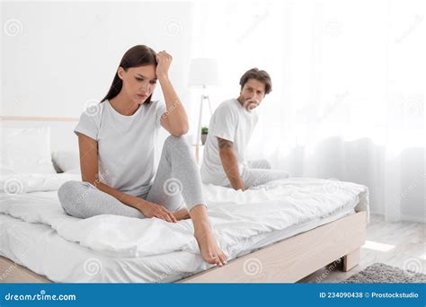 Unhappy Upset Offended Millennial Caucasian Woman Sitting On Bed