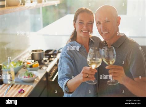 Portrait Happy Mature Couple Toasting White Wine Glasses Cooking In Kitchen Stock Photo Alamy