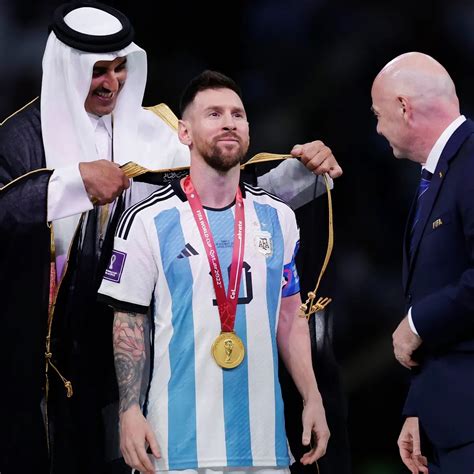 Messi mặc áo choàng đen nâng cúp vàng World Cup nhiều cổ động viên