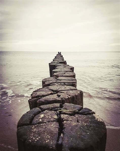 A Long Stone Wall Stretches Out Into The Ocean