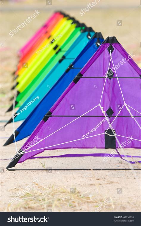 A Stack Of Stunt Kites In Rainbow Colours On The Ground Ready To Fly