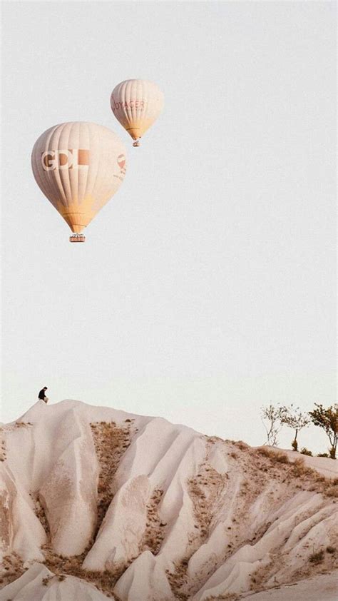 Two Hot Air Balloons In The Sky Above Sand Dunes