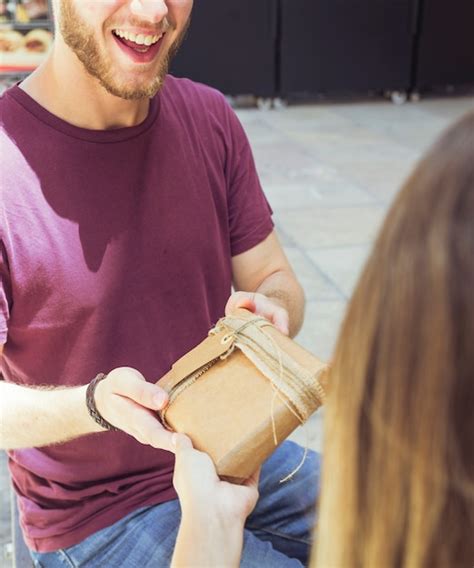 Primer Plano De Un Hombre Feliz Dando Un Regalo A Su Novia Foto Gratis