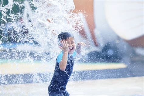 Muchacho Asiático Lindo Que Juega En El Parque Del Agua Imagen de