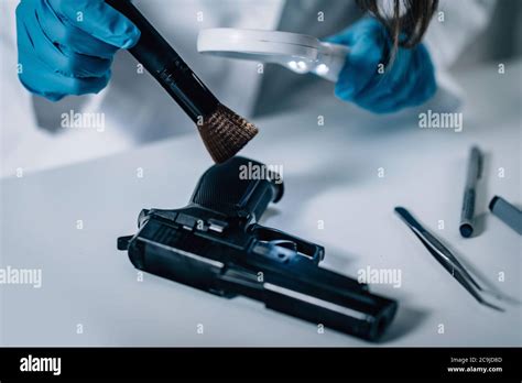 Forensic Science In Lab Forensic Scientist Examining Gun For Evidence