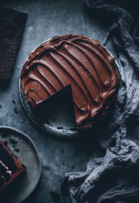 A Piece Of Chocolate Cake On A Plate Next To A Knife And Fork With One