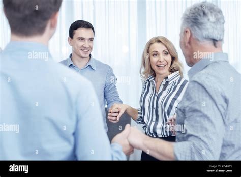 Positive Delighted People Holding Hands Stock Photo Alamy