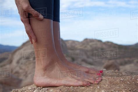 Cropped Image Of Woman S Bare Feet Standing On Rocks Stock Photo