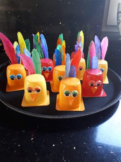 Colorful Plastic Birds With Eyes And Feathers On A Black Plate