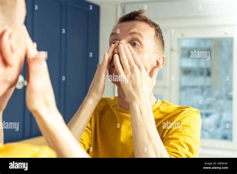 Mature Man Apply Cosmetic Product On Face Then Massage With Hands Male Portrait In Mirror
