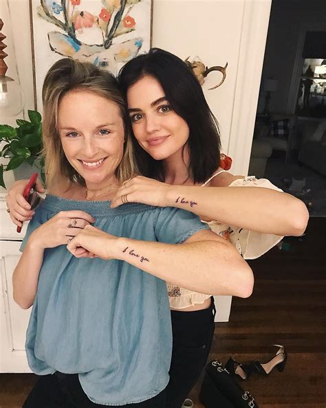 Two Women Hugging Each Other With Tattoos On Their Arms And Chest Both