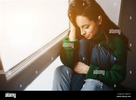 Unhappy Young Woman Is Sad Near The Window The Brunette Is Crying