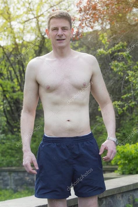 Man Standing Shirtless Outdoors In A Park Stock Photo Wernerimages