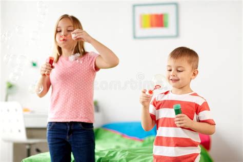 Bambini Che Soffiano Le Bolle Di Sapone E Che Giocano A Casa Fotografia